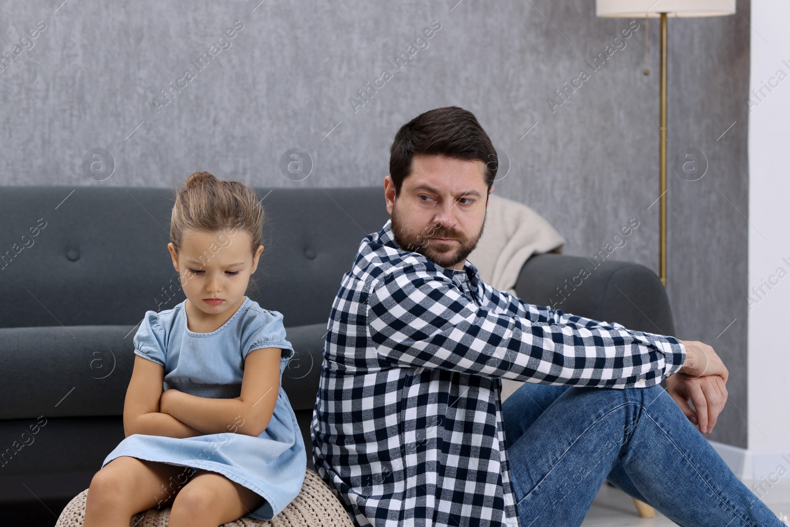 Photo of Resentful little girl and her father arguing at home