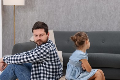 Photo of Resentful little girl and her father arguing at home