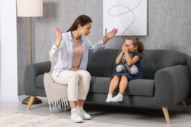 Photo of Resentful little girl and her mother arguing at home