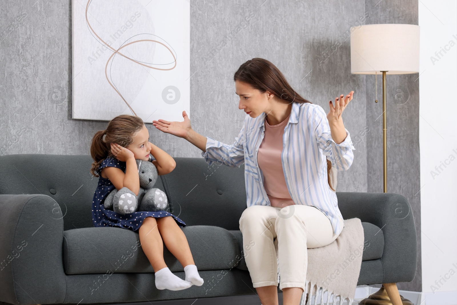 Photo of Resentful little girl and her mother arguing at home