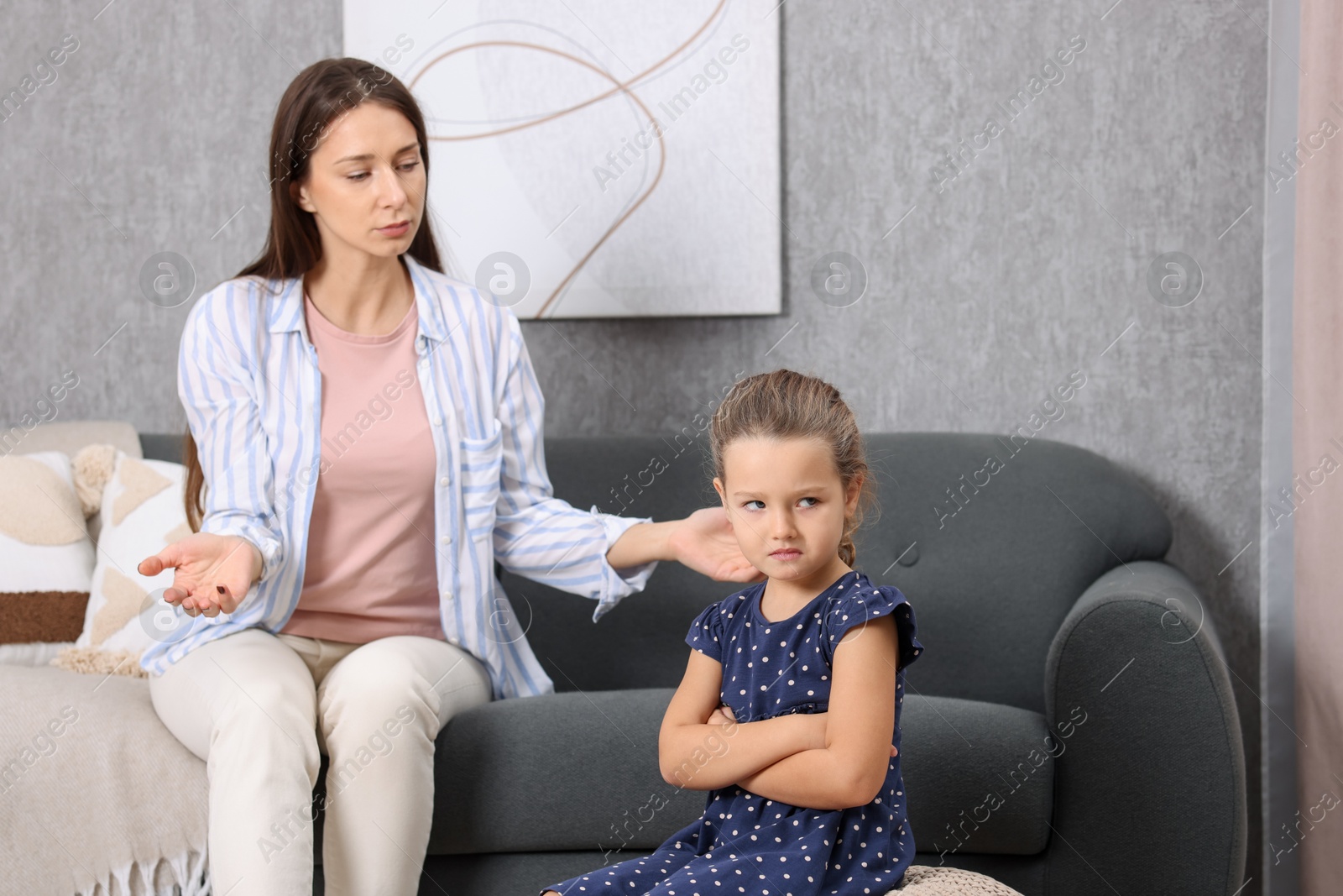 Photo of Resentful little girl and her mother arguing at home