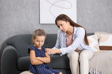 Photo of Resentful little girl and her mother arguing at home