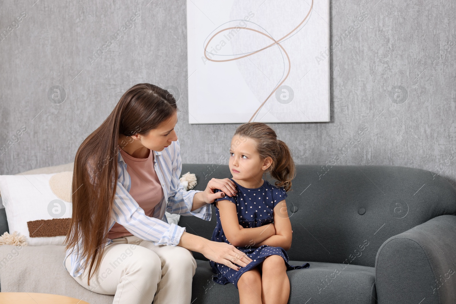 Photo of Resentful little girl and her mother arguing at home