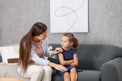 Photo of Resentful little girl and her mother arguing at home