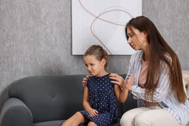 Photo of Resentful little girl and her mother arguing at home