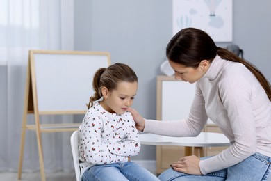 Photo of Resentful little girl and her mother at home