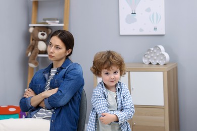 Photo of Resentful little boy and his mother arguing at home