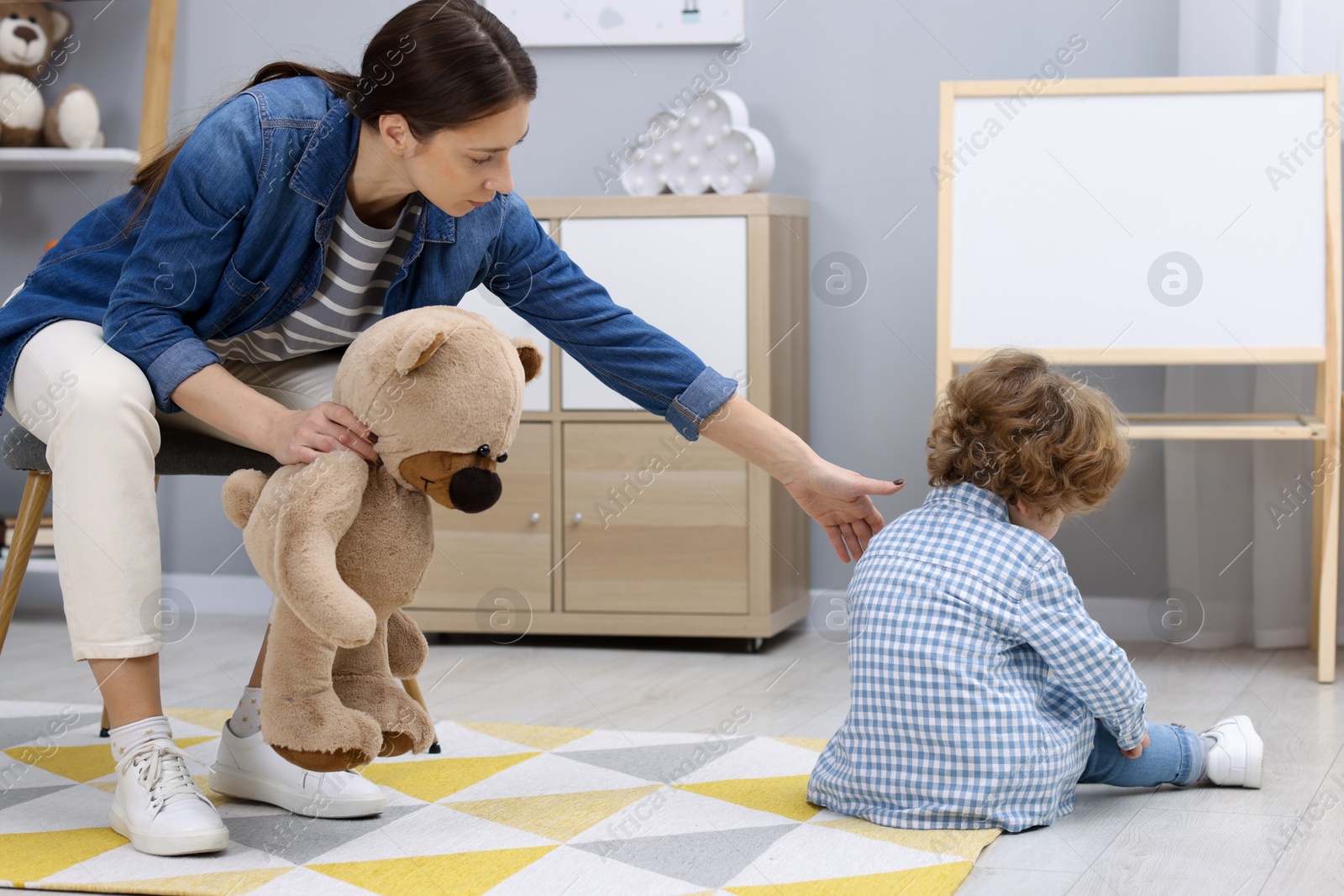 Photo of Resentful little boy and his mother arguing at home