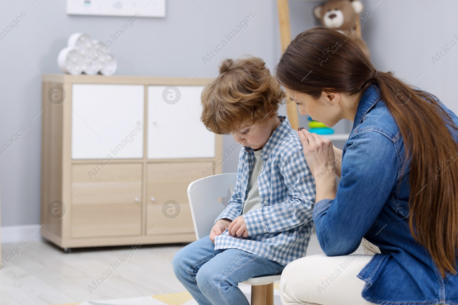 Photo of Resentful little boy and his mother at home, space for text. Family dispute