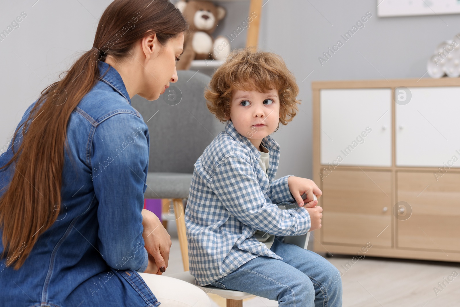 Photo of Resentful little boy and his mother arguing at home