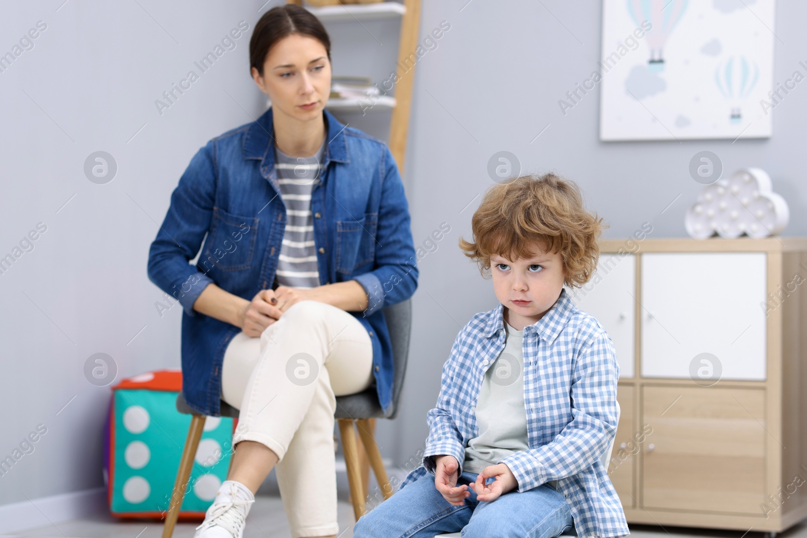 Photo of Resentful little boy and his mother arguing at home