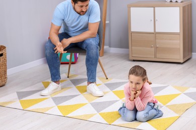 Photo of Resentful little girl and her father arguing at home