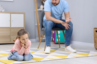 Resentful little girl and her father arguing at home