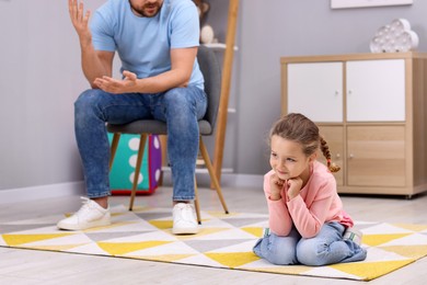 Photo of Resentful little girl and her father arguing at home