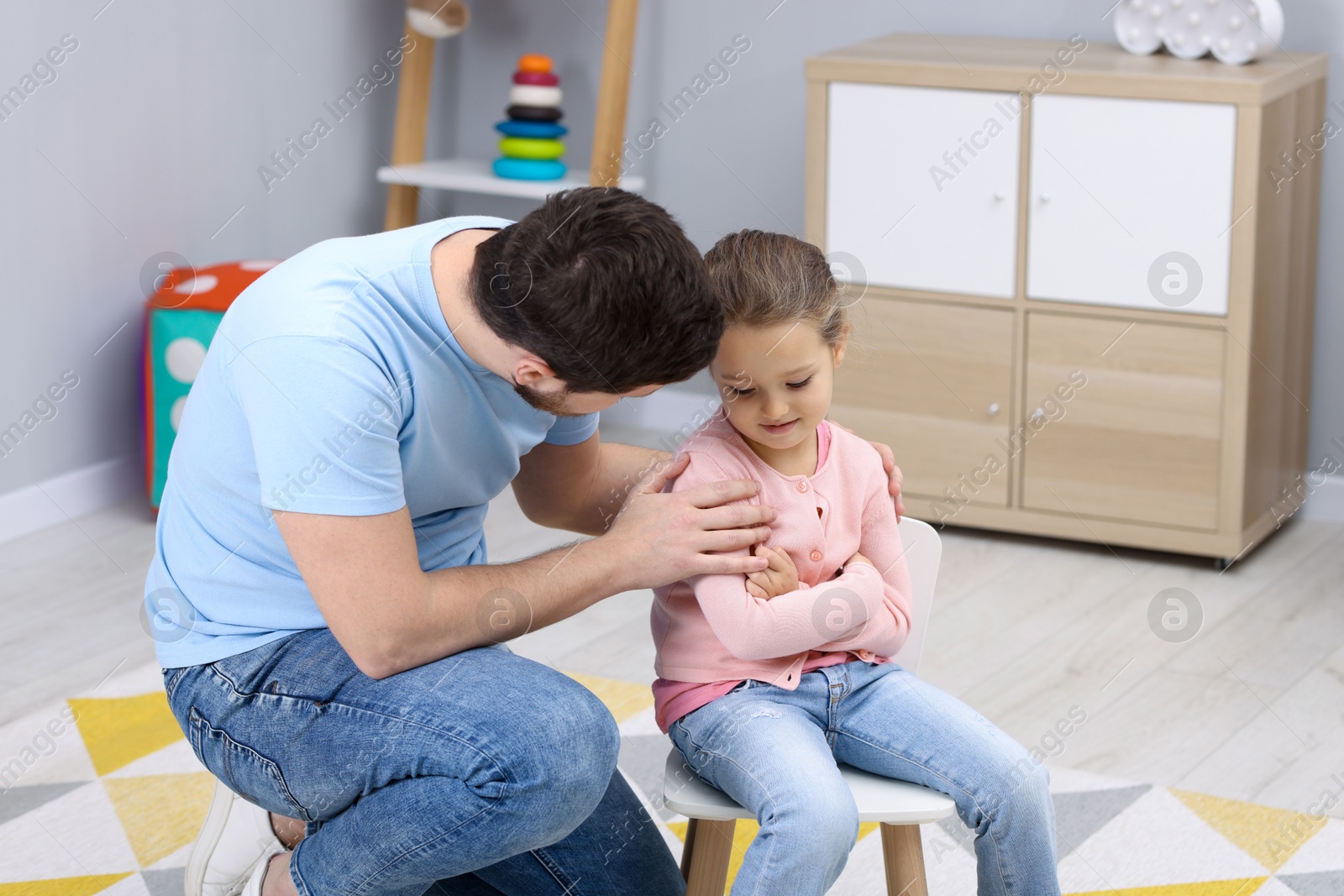 Photo of Resentful little girl and her father at home. Family dispute