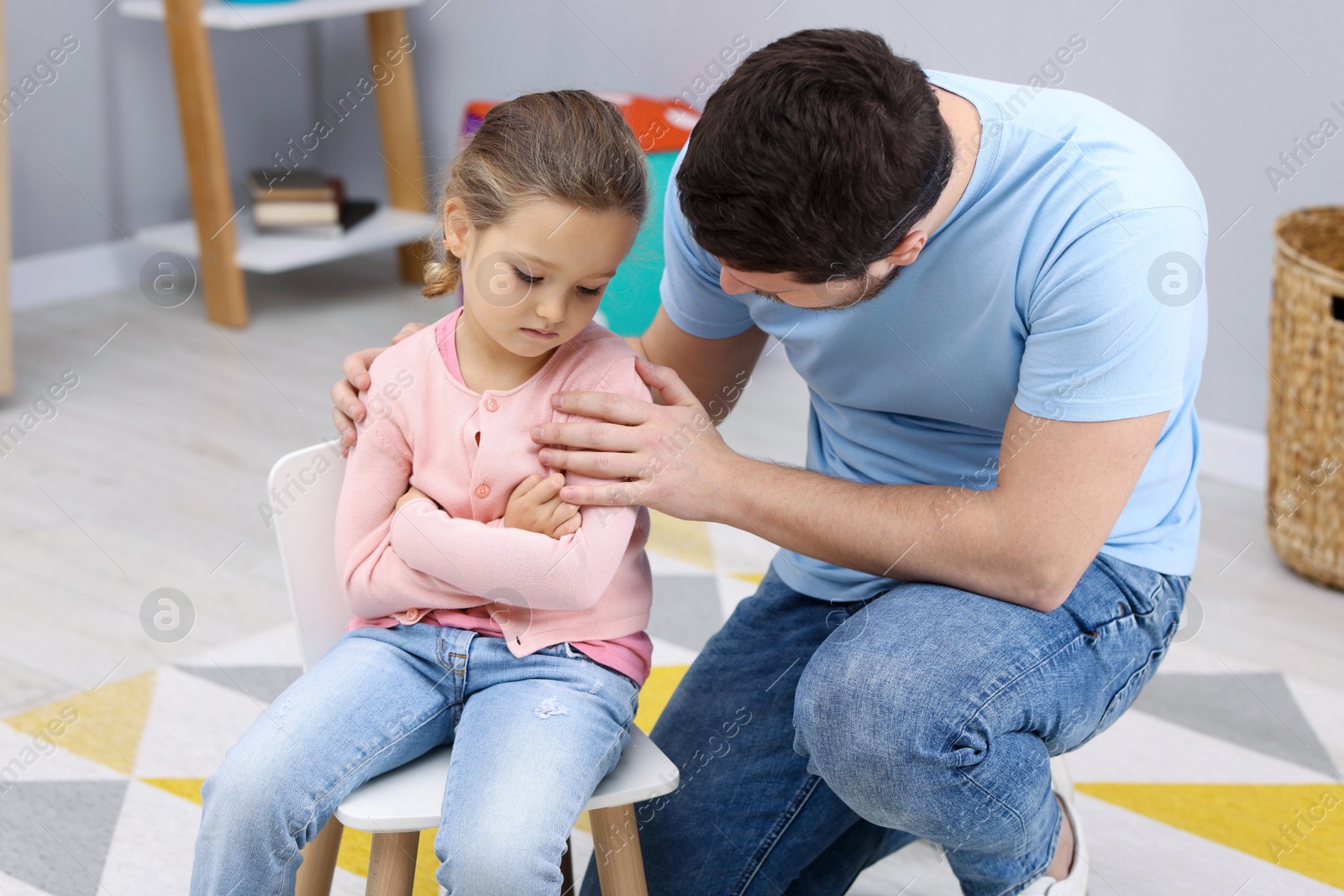 Photo of Resentful little girl and her father at home. Family dispute