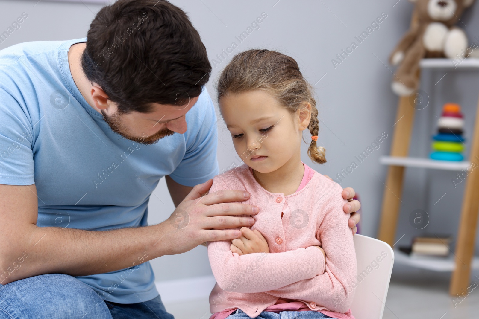 Photo of Resentful little girl and her father at home. Family dispute