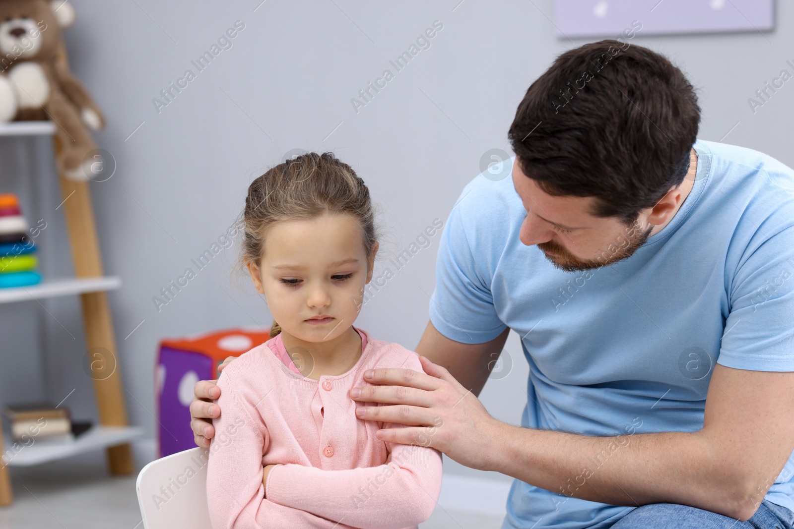 Photo of Resentful little girl and her father at home. Family dispute