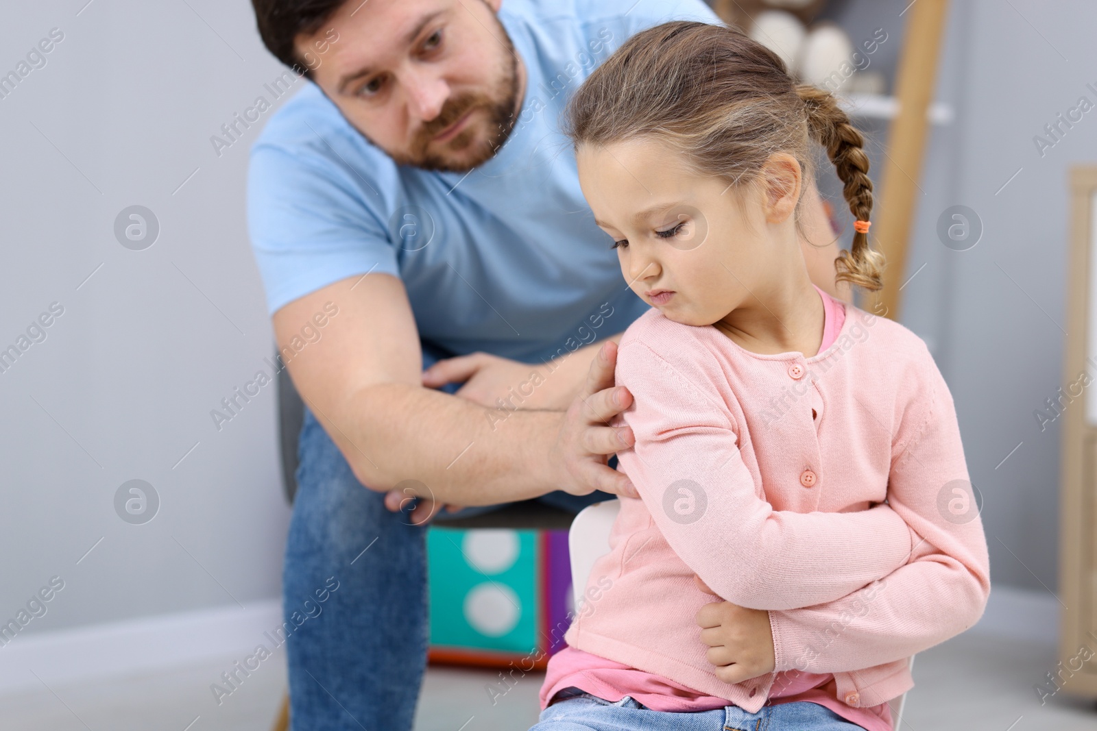 Photo of Resentful little girl and her father at home. Family dispute