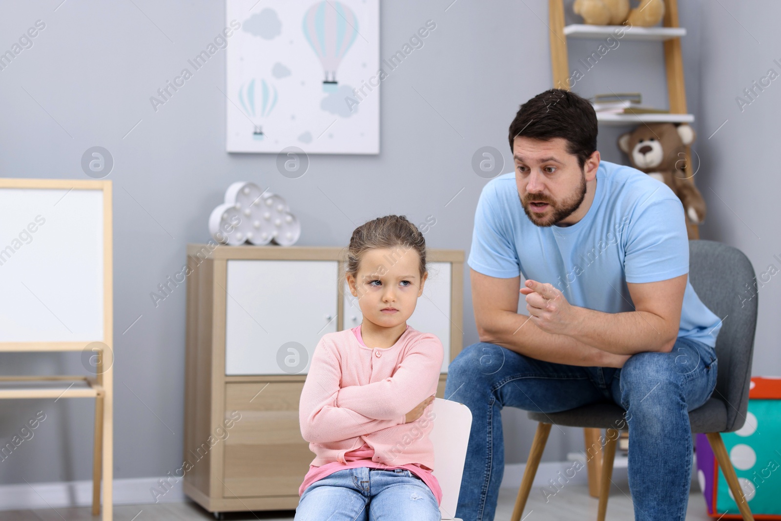 Photo of Resentful little girl and her father arguing at home