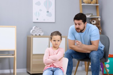 Resentful little girl and her father arguing at home