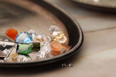 Photo of Tray with beautiful gemstones on light table, closeup