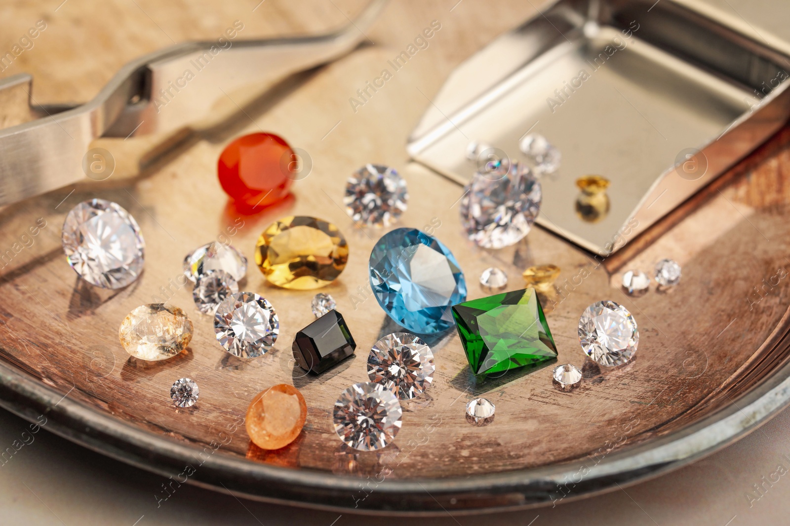 Photo of Tray with beautiful gemstones on light table, closeup