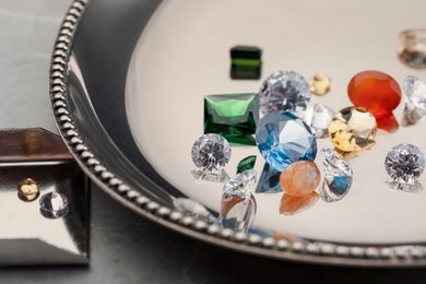 Photo of Tray with beautiful gemstones on light table, closeup