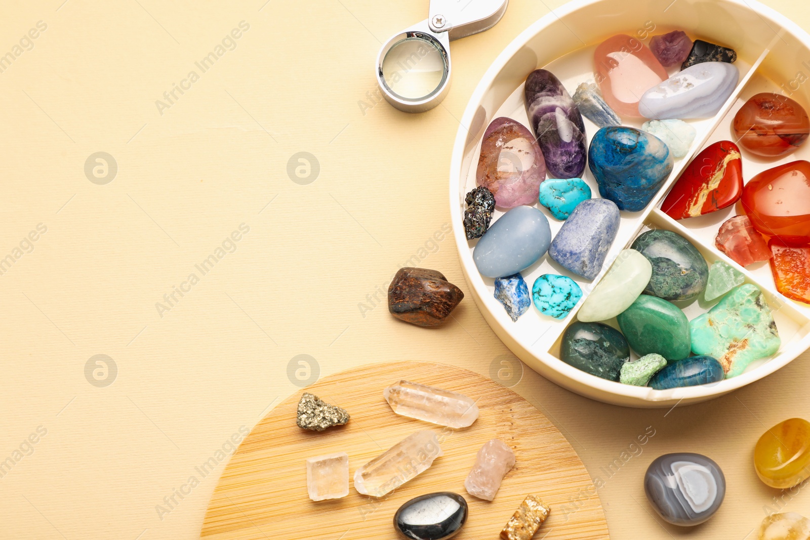 Photo of Box with beautiful gemstones on beige background, flat lay. Space for text