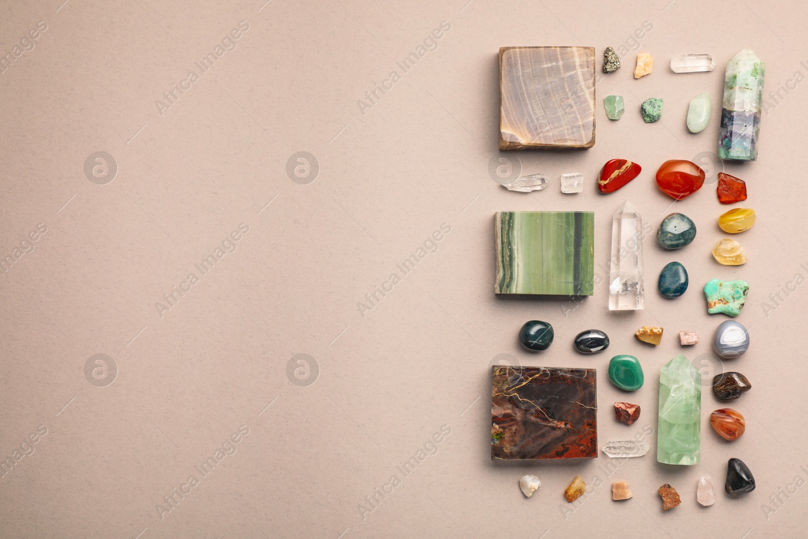 Photo of Different natural gemstones on light background, flat lay. Space for text