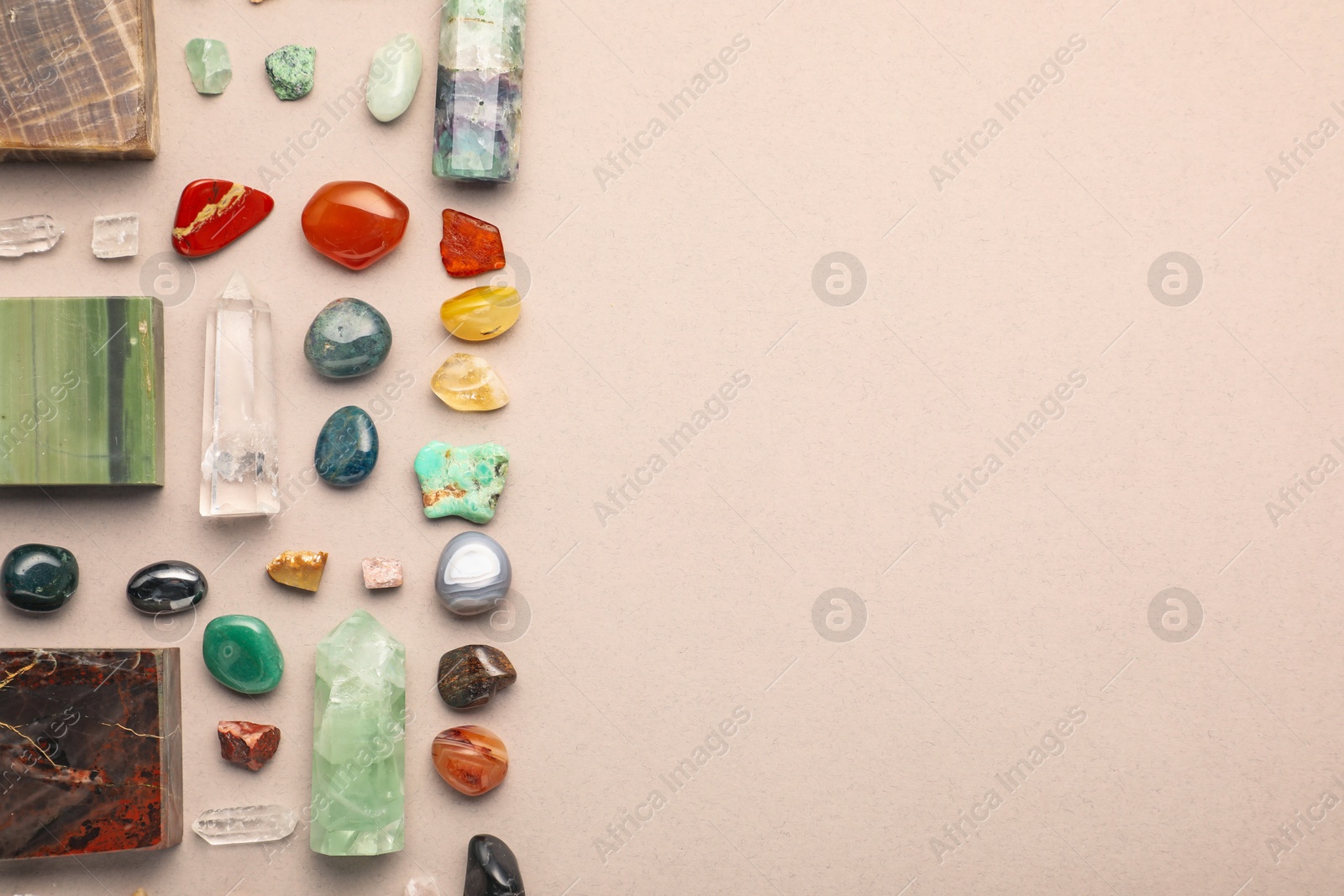 Photo of Different natural gemstones on light background, flat lay. Space for text