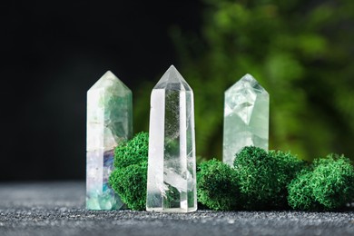 Photo of Natural gemstones and moss on grey textured table, closeup