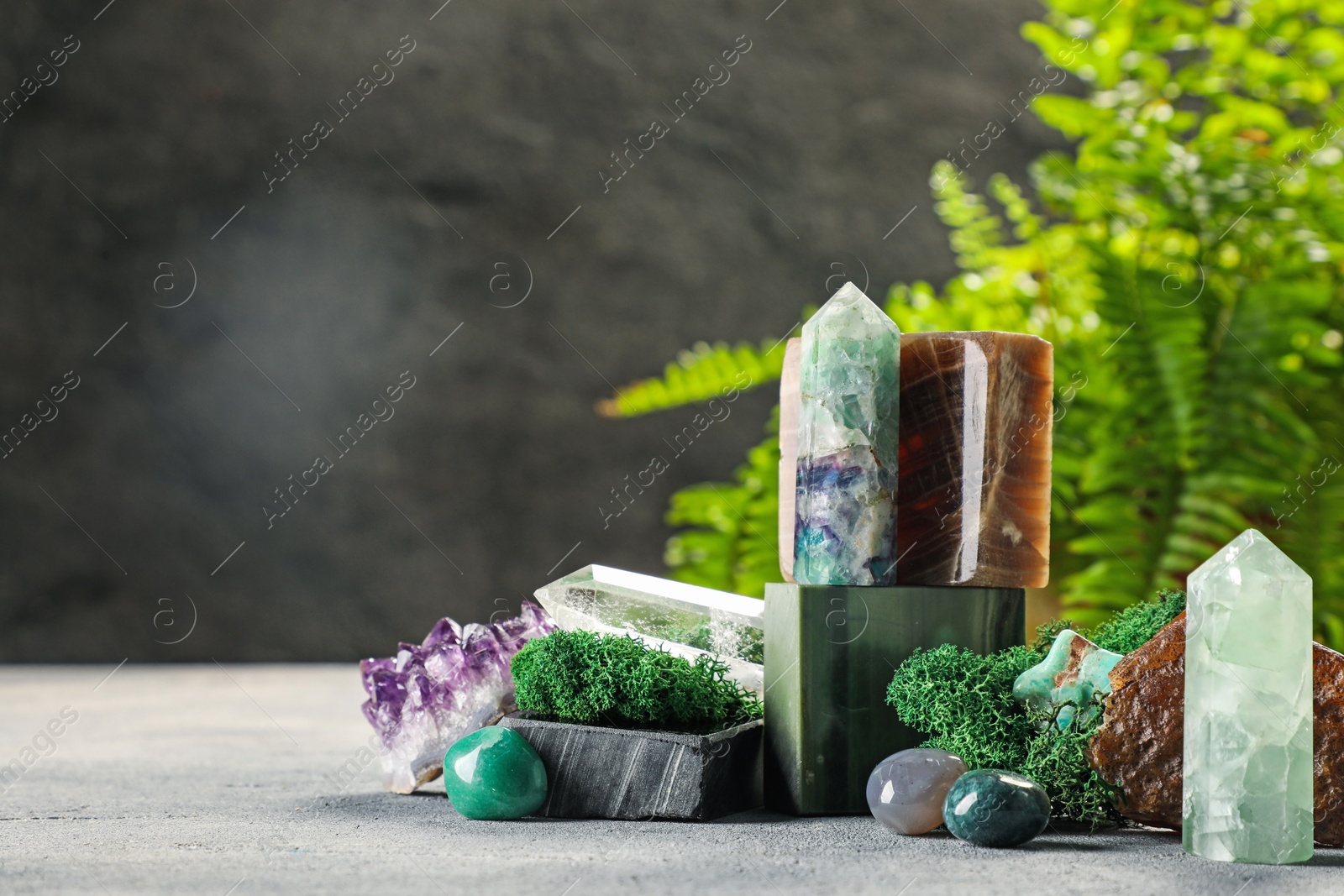 Photo of Natural gemstones and moss on light table. Space for text