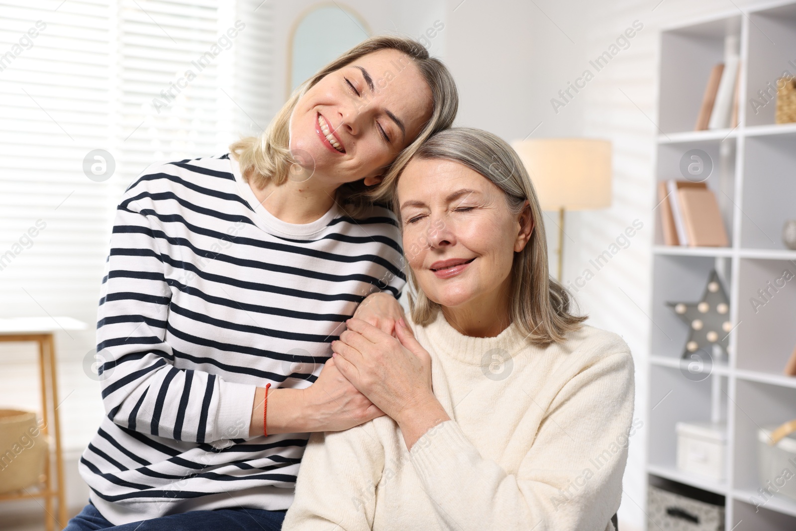 Photo of Smiling daughter and her mother at home