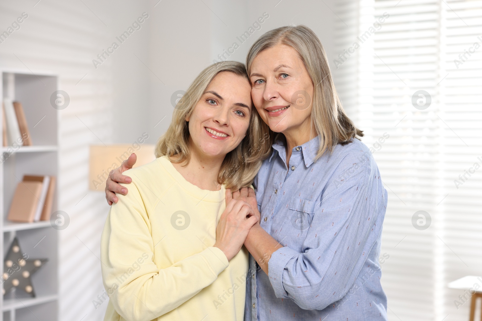 Photo of Family portrait of smiling mother and her daughter at home