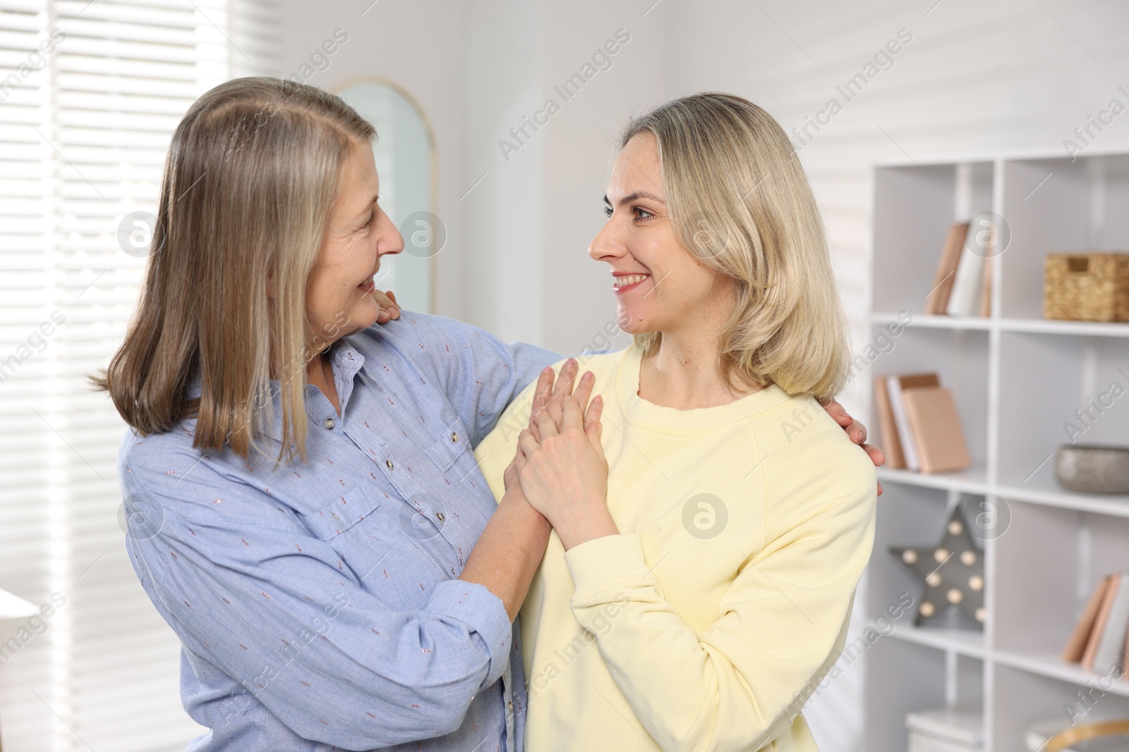 Photo of Smiling mother and her daughter at home