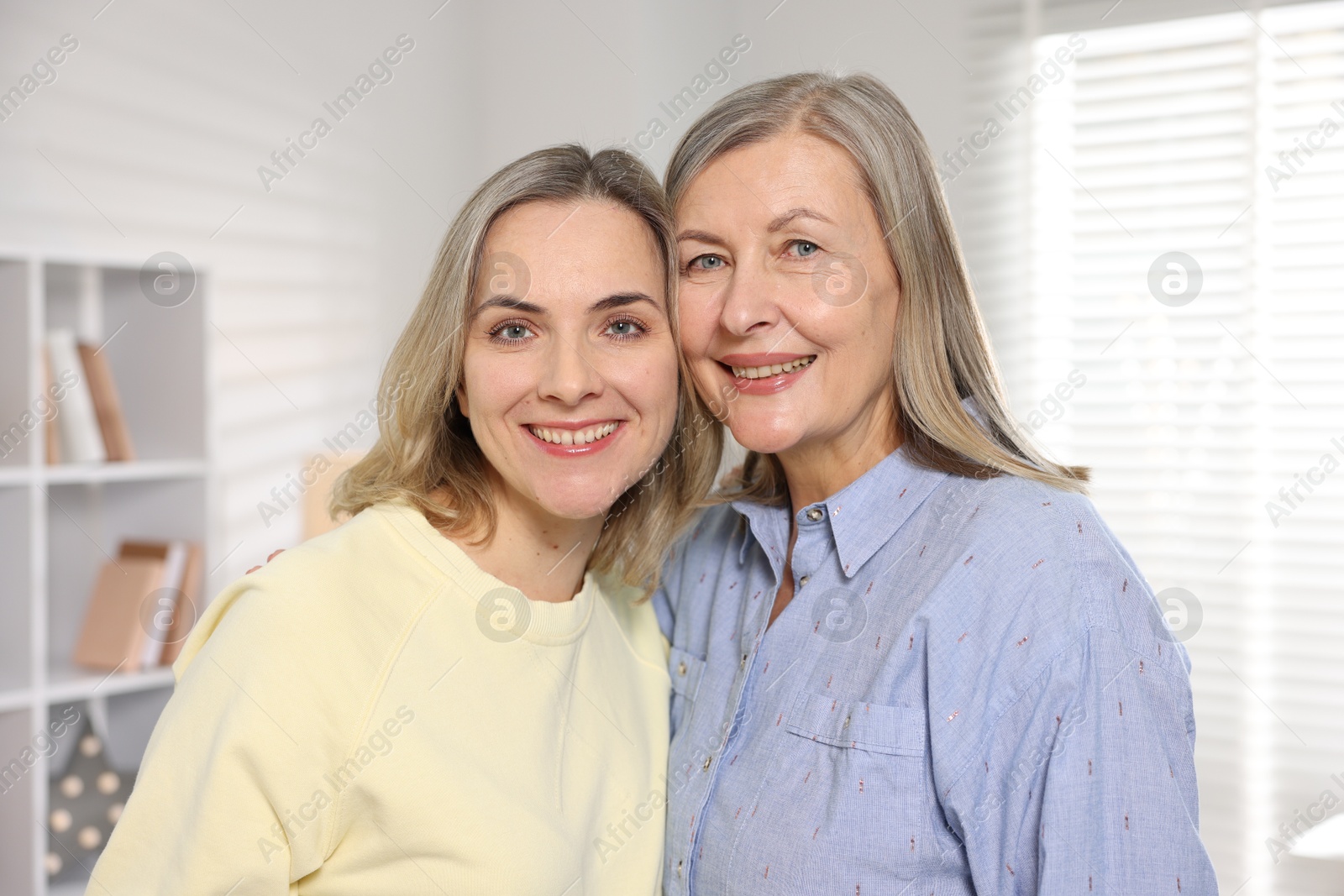 Photo of Family portrait of smiling mother and her daughter at home