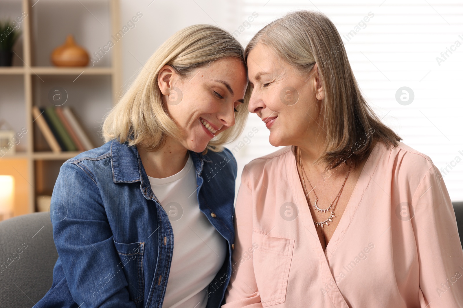 Photo of Smiling daughter and her mother at home