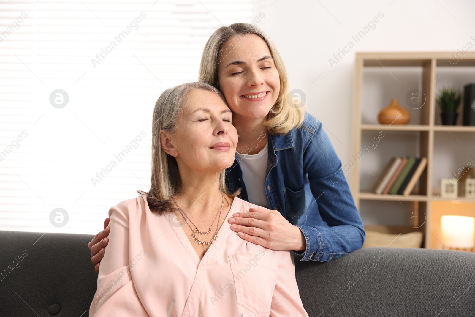 Photo of Smiling daughter and her mother at home