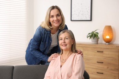 Photo of Smiling mother and her daughter at home