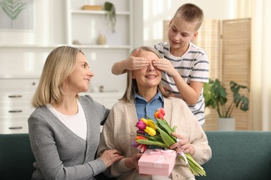 Photo of Mother and son congratulating their happy parent with Mother's Day at home