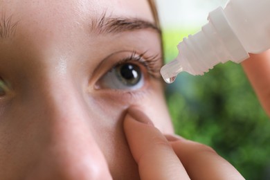 Photo of Allergy treatment. Woman dripping medical drops into eyes on blurred background, closeup