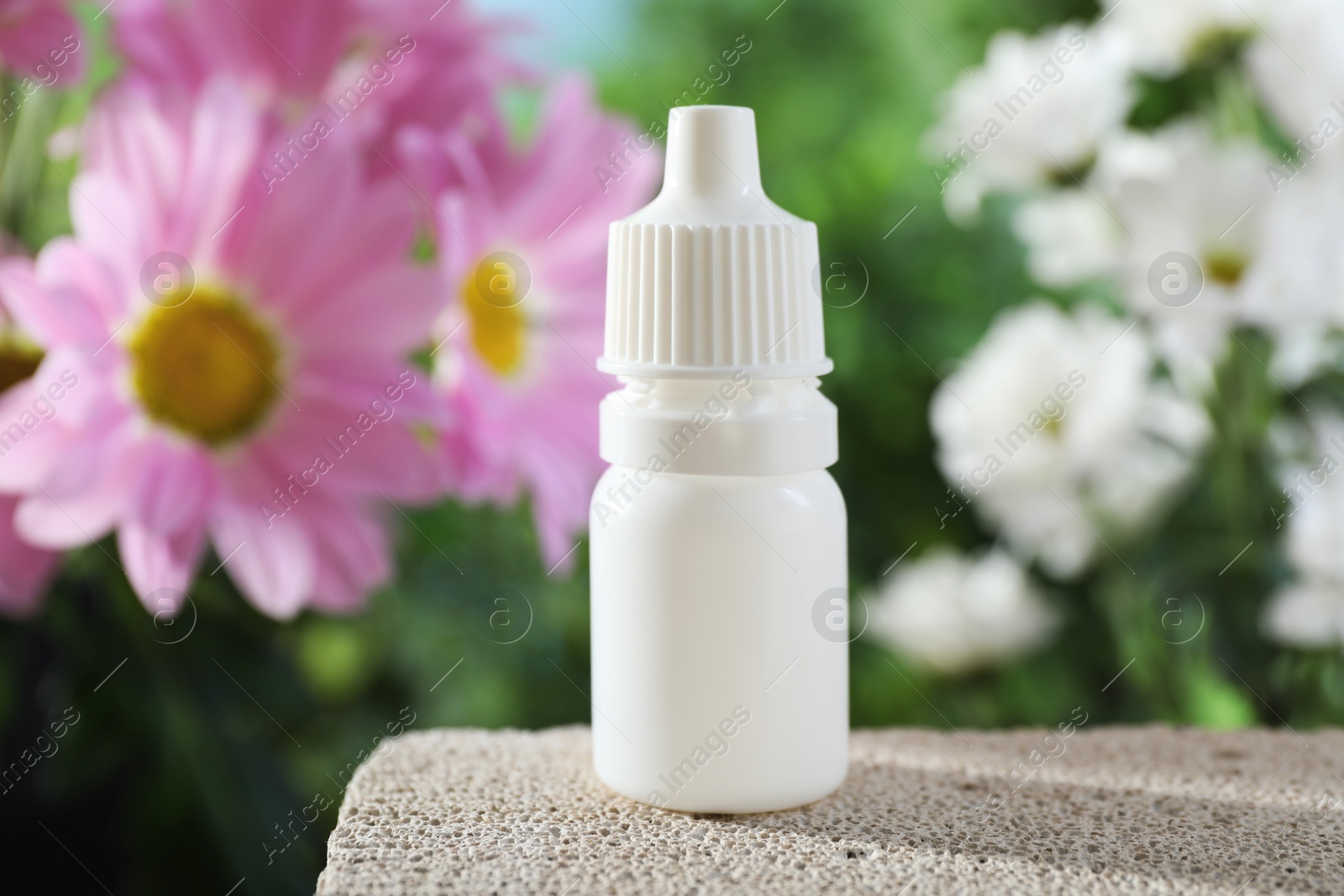 Photo of Allergy treatment. Bottle of medical drops on stone against blurred background, closeup