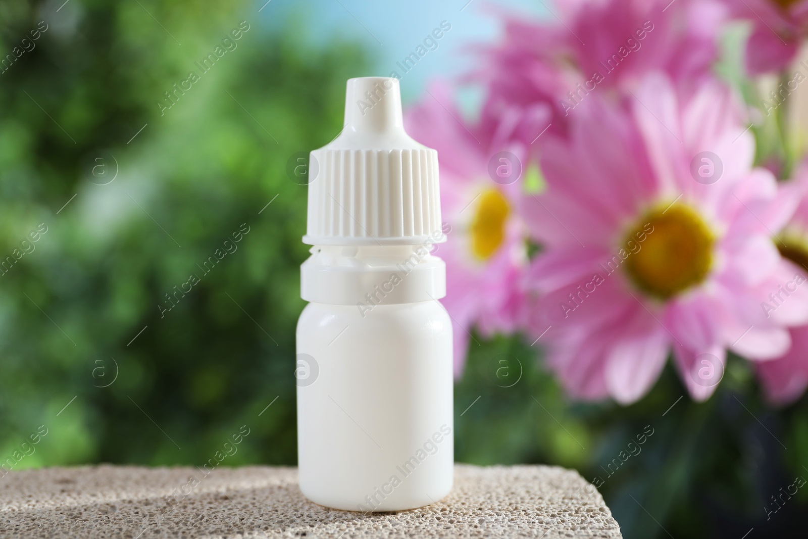 Photo of Allergy treatment. Bottle of medical drops on stone against blurred background, closeup