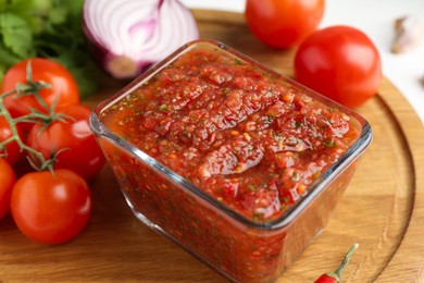 Photo of Delicious salsa sauce and products on white table, closeup