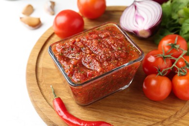 Photo of Delicious salsa sauce and ingredients on white table, closeup