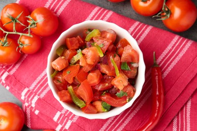 Photo of Delicious salsa (Pico de gallo) in bowl and chili pepper on grey table, flat lay