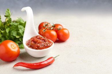 Photo of Delicious salsa sauce and ingredients on light textured table, closeup. Space for text