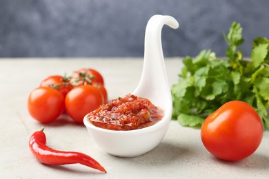 Photo of Delicious salsa sauce and ingredients on light textured table, closeup