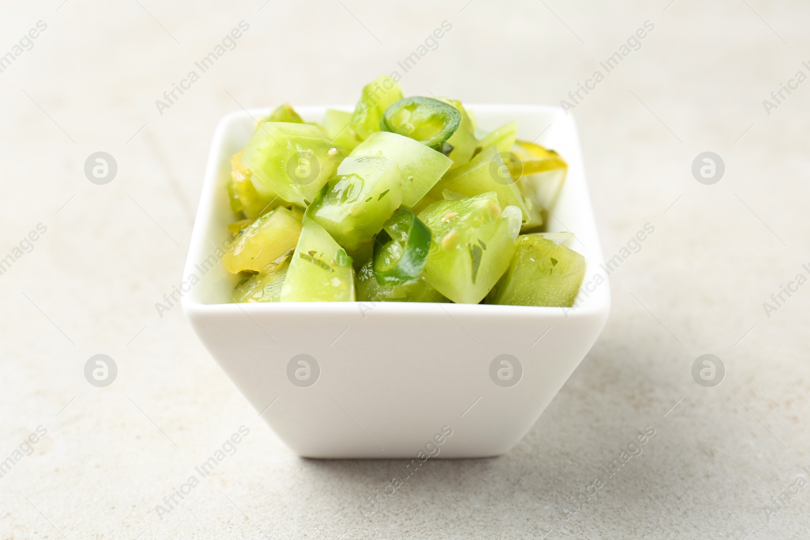 Photo of Delicious salsa (Pico de gallo) in bowl on light textured table, closeup